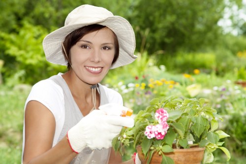 Workers wearing protective gear trimming hedges